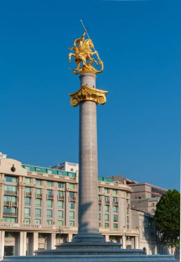 Georgia.Tiflis. Özgürlük Meydanı 'ndaki Aziz George Anıtı. Heykel mavi gökyüzüne karşı altın ve pırıltılarla kaplı..