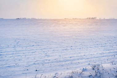 Alan karla kaplı. Karda batan güneşin yansıması..
