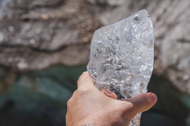 Georgia. Chalaadi Buzulu. Adamın elinde şeffaf bir buz parçası..