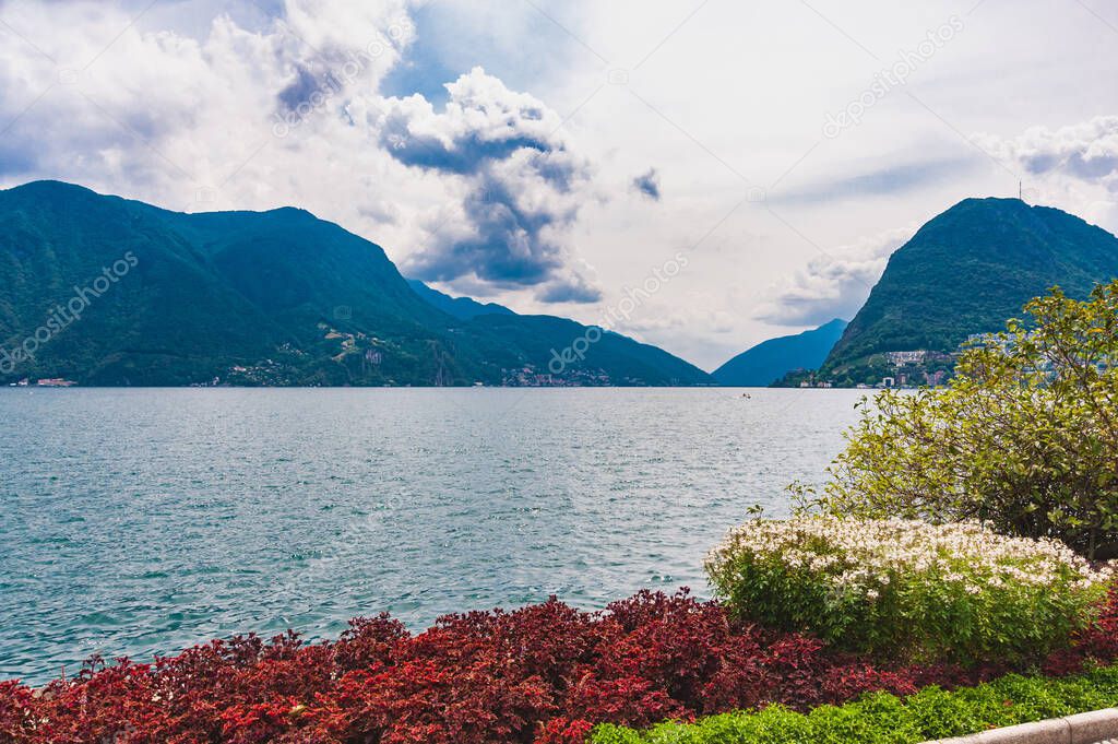 Europe. Switzerland.Park in Lugano, lake, mountains. Blue sky with clouds.Copy space.
