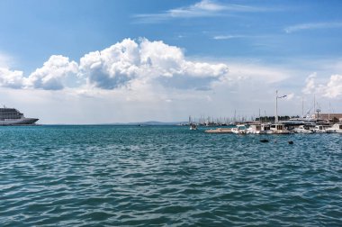 Hırvatistan. Adriyatik Denizi manzarası. Mavi gökyüzü manzaralı beyaz bulutlar. Yatlar piercingin yanında..