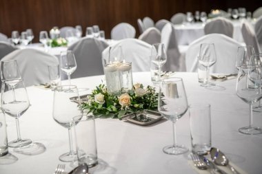 Oturma odasında masalar ve cam eşyalar olan şık bir sofra..