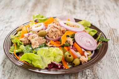 Ton balıklı salata, karışık marul, kırmızı soğan, havuç ve yeşil zeytin.