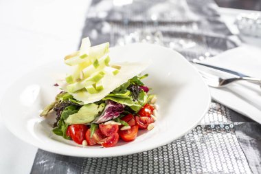 Kiraz domatesli, elmalı, çam fıstıklı ve otlu taze sağlıklı salata.