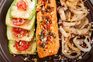 fırında somon filetosu, kabaklı domates ve soğan halkaları.