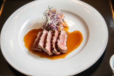 Sos ve salata serpiştirilmiş bir tabak et.