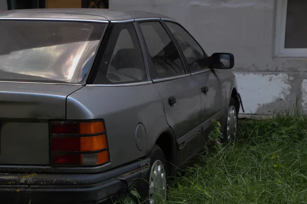 80年代のヴィンテージ車は庭で放棄されました ヴィンテージグレーの車側のビュー — ストック写真