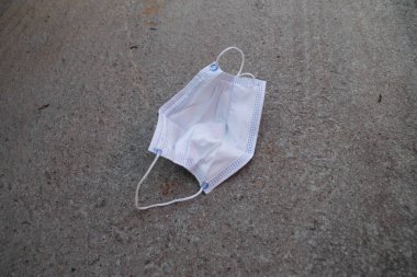 Bir çok kez giydikten sonra, yerde fotokopi alanı olan kirli bir arka yüz maskesi.