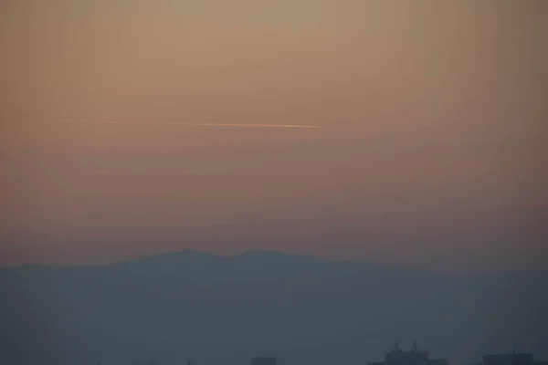 Blick Auf Einen Hügel Bei Sonnenuntergang Mit Flugzeugspuren — Stockfoto