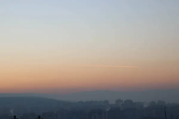 Vuur Lucht Stad Tijdens Zonsondergang Een Spoor Van Vliegtuig — Stockfoto