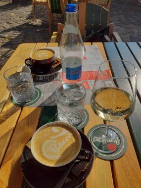 Şarap ve kahve molası. Masada 2 bardak kahve, şarap ve su var..