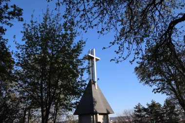 Çapraz çatılı soyut bir bina ve temiz gökyüzü olan ağaçlar..