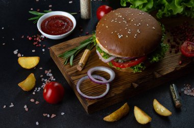 Çiğ pirzola ve peynirli hamburger, soğan, marul yaprağı ve domatesli geleneksel susamlı çörekler. Bir parça metin ekleme yeteneğine sahip güzel arkaplan