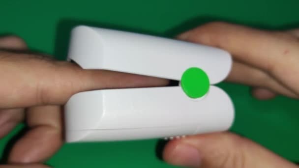 パルス酸素計を使う 血中酸素飽和度測定器 緑の背景 ヘルスケアの概念 医療技術 コロナウイルス 4Kビデオ — ストック動画