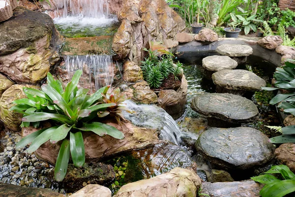 Pond in a beautiful garden with a small waterfall. Indonesia. — Stock Image Pond Beautiful Garden Small Waterfall Indonesia Stock Photo