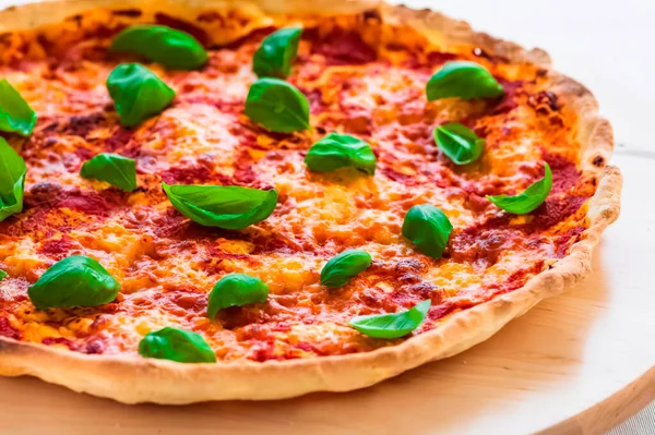 Pizza Margherita on a thin crust. Close-up, baked in a wood-fired pizza oven.  Italian cuisine. Gourmet meal.
