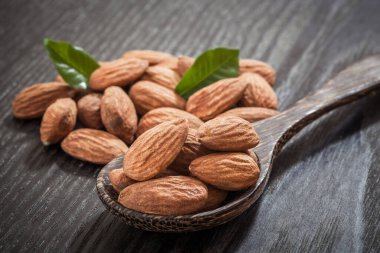 Tahta zemin üzerinde yaprakları olan bademler