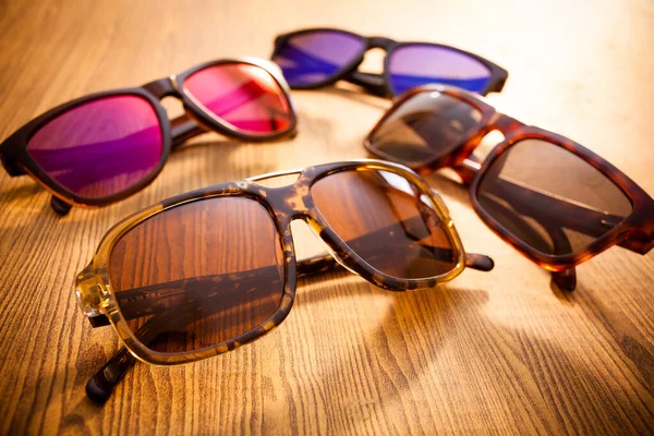 Collection of sunglasses on wood background