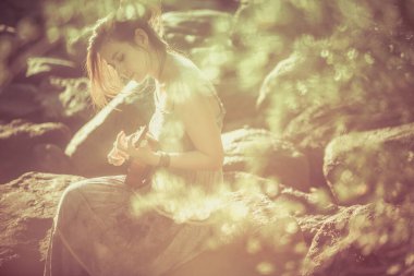 Güneş ışığı kumsalında ukulele çalan kadın.