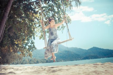 Kadın güneş ışığı plajında doğanın tadını çıkarıyor.