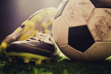 Yeşil çimlerin üzerinde futbol ayakkabıları ve futbol