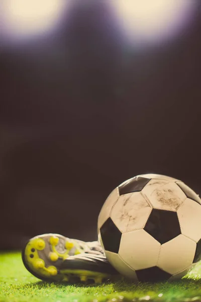 Yeşil çimlerin üzerinde futbol ayakkabıları ve futbol