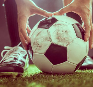 Yeşil çimlerin üzerinde futbol ayakkabıları ve futbol