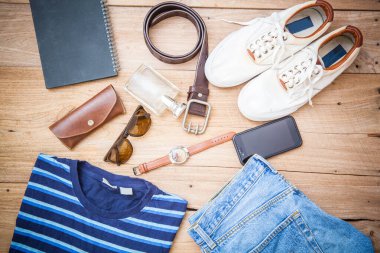 Ahşap arka planda sıradan kıyafet koleksiyonu.