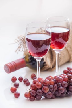Kırmızı şarap ve üzüm, beyaz arka plan.