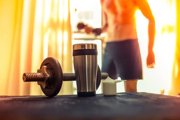 Whey protein shaker and dumbbells