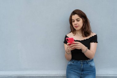 Akıllı telefonunu kullanan ve mesaj gönderen genç bir kız..