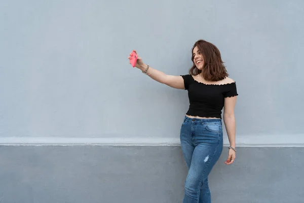 Młoda Dziewczyna Robi Sobie Selfie Uśmiecha Się Niebieską Ścianą Tle — Zdjęcie stockowe
