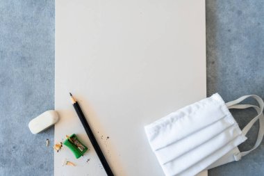 Beyaz kağıt kalem ve yüz maskesi ile evde çizim kavramı. 