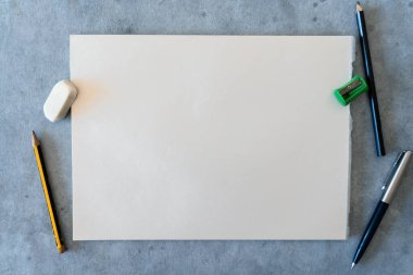 Çizim elemanları, kalemler, silgi ve kalem açacağı olan beyaz bir sayfa.. 