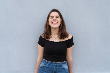 Kameraya gülümseyen mutlu genç bir kadın. Şehir tarzı.