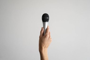 Adamın eli mikrofonu dikey olarak tutuyor şarkıcı ve müzik kavramı.
