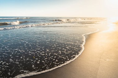 Gün batımında güneşi yansıtan deniz kıyısı..