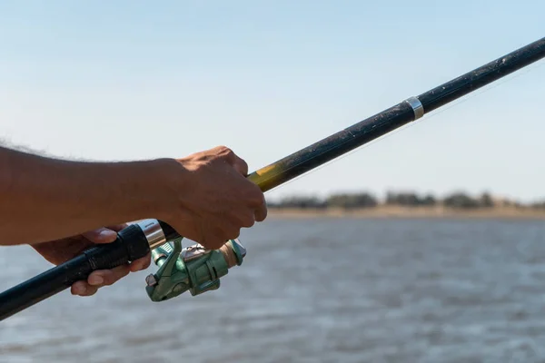 Close Mãos Pescador Segurando Sua Vara Pesca Com Lago Fundo — Fotografia de Stock