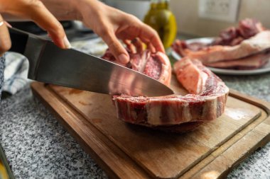 Şefin elleri kısa kaburgaları keser ve onları pişirmeye hazırlar..