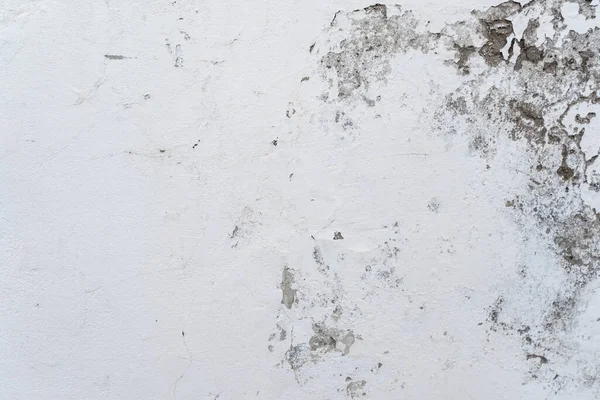 White wall with damp stains in the paint on the right side. Texture background wallpaper.