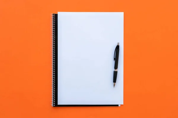 Blankobogen Mit Notizbuch Und Stift Auf Orangefarbenem Hintergrund — Stockfoto