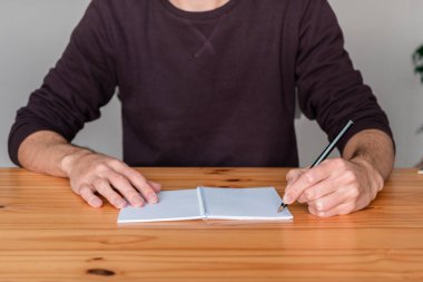 Adamın kişisel not defterine not aldığı yakın plan..