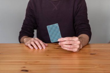 Elinde bir iskambil kartı tutan tanınmayan kişi