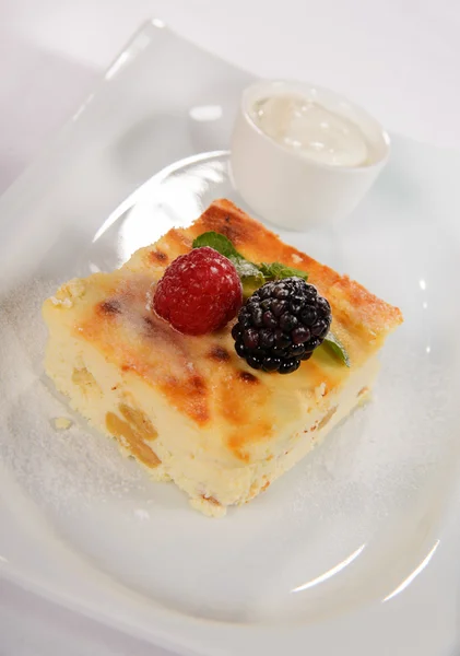 Baked pudding for breakfast with fresh berries and sour cream