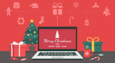 Mutlu Noeller ve mutlu yeni yıl mektupları dizüstü bilgisayarda Noel ikonu ile ve hediyeler, şekerler, fincanlar ve masanın üzerindeki Noel ağacı ile süslenir.