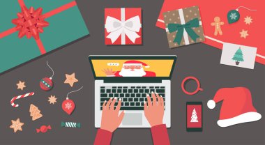 Noel tatili için Noel Baba 'ya dizüstü bilgisayar görüntüsü kullanan bir insan eli kavramı hediye, kurabiye, Noel Baba şapkası ve kartpostal, düz çizim.