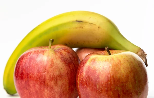 Een banaan en drie appelen — Stockfoto