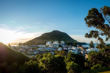 Pilot bölümünden gün batımında Maunganui Dağı 'na ve Drury Tauranga Dağı' na