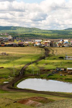 Güneşli bir bahar gününde bahar tepeleri. Tepelerin tepesinden şehrin manzarası