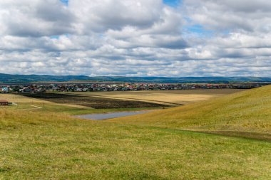 Güneşli bir bahar gününde bahar tepeleri. Tepelerin tepesinden şehrin manzarası